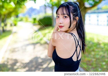 一個有著美麗背部的酷女人在陽光下的路上鍛煉,散步,鍛煉,鍛煉 一個有著美麗背部的酷女人在陽光下的路上鍛煉,散步,鍛煉,鍛煉 122882446