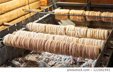 Trdelnik. Traditional dessert baked in an open fire wooden stake in Dresden Christmas Market. Trdelnik. Traditional dessert baked in an open fire wooden stake in Dresden Christmas Market. 122882491