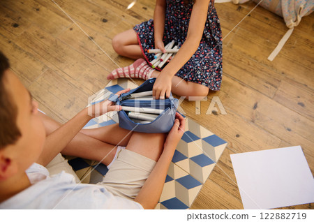 Children organizing stationery supplies together Children organizing stationery supplies together 122882719