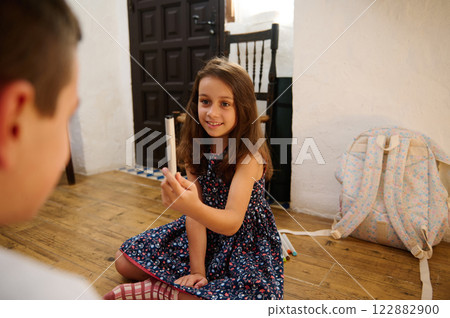 Girl sharing a pencil indoors Girl sharing a pencil indoors 122882900