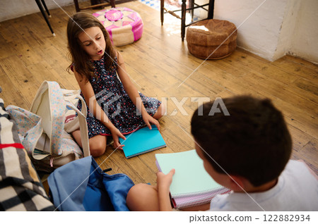 Children Sitting with Notebooks Indoors 122882934
