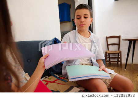 Children sharing colorful notebooks indoors Children sharing colorful notebooks indoors 122882958