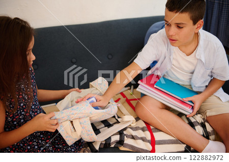 Children sorting school supplies together Children sorting school supplies together 122882972