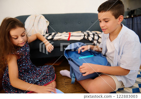 Kids organizing school supplies together Kids organizing school supplies together 122883003