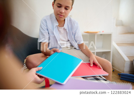 Boy sharing colorful notebooks together 122883024