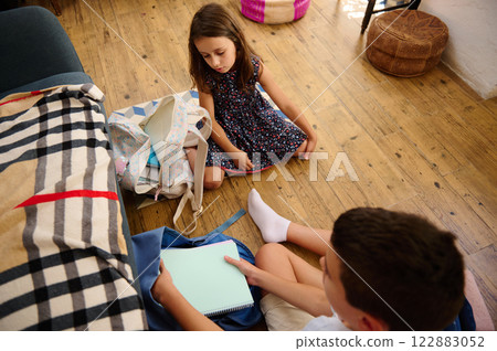 Children Packing Bags on Wooden Floor Children Packing Bags on Wooden Floor 122883052