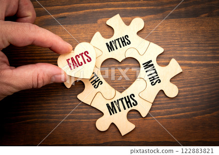Facts vs myths concept. Wooden puzzle in the shape of a heart on a wooden texture background Facts vs myths concept. Wooden puzzle in the shape of a heart on a wooden texture background 122883821