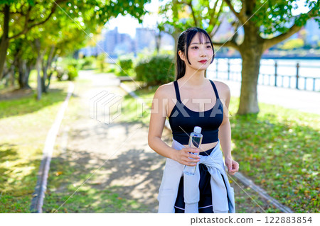 一位酷酷的女人在陽光下沿著小路散步補充水分 飲食 運動 運動 122883854