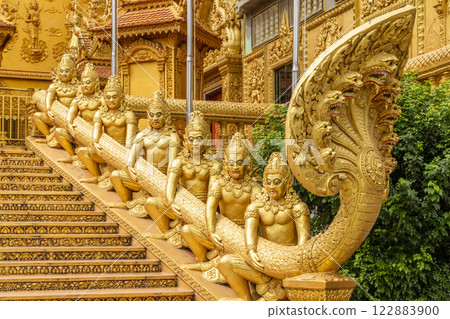 Many asura titans statues holding Naga snake statue, Wat Kean Kleang golden temple, Phnom Penh, Cambodia Many asura titans statues holding Naga snake statue, Wat Kean Kleang golden temple, Phnom Penh, Cambodia 122883900