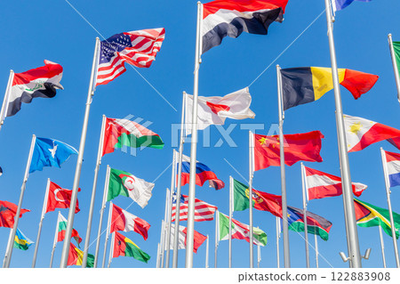 Many world's countries national flags waving together on the wind, with American, Japanese, Omani, Chinese, Russian, Somalian, Algerian banners in the foreground, Doha, Qatar 122883908