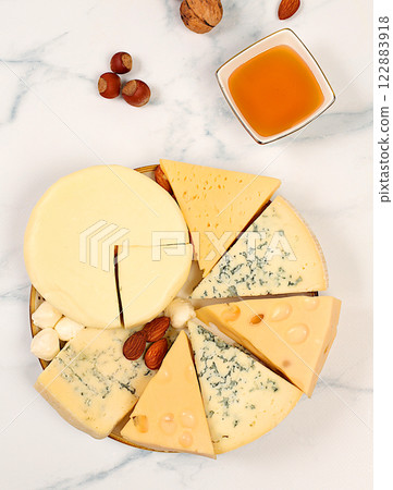 Blue cheese, gorgonzola, roquefort, parmesan, mozzarella, maasdam with honey and nuts, Assortment of different types of cheese, healthy and natural food selection, advertising postcard for cafe and Blue cheese, gorgonzola, roquefort, parmesan, mozzarella, maasdam with honey and nuts, Assortment of different types of cheese, healthy and natural food selection, advertising postcard for cafe and 122883918