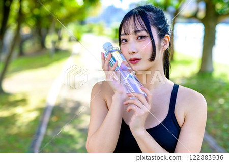 一位酷酷的女人在陽光下沿著小路散步補充水分 飲食 運動 運動 122883936
