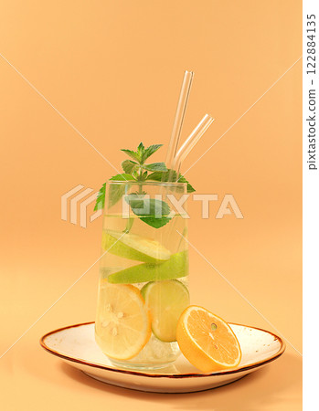 Detox water with lemon, cucumber, lime and mint flavors on a light background. A refreshing summer homemade lemonade cocktail. Fruit juice and ingredients, weight loss concept, healthy and natural Detox water with lemon, cucumber, lime and mint flavors on a light background. A refreshing summer homemade lemonade cocktail. Fruit juice and ingredients, weight loss concept, healthy and natural 122884135