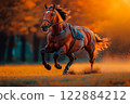 A powerful horse runs swiftly across an open field, surrounded by autumn foliage. The vibrant colors and sharp details capture the speed and grace of the animal in motion. 122884212