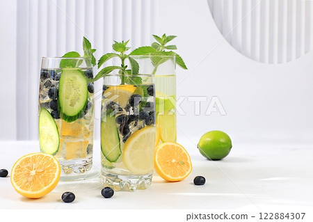 Detox water with lemon, cucumber, blueberry and mint flavors on a light background. A refreshing summer homemade lemonade cocktail. Fruit juice and ingredients, weight loss concept, Detox water with lemon, cucumber, blueberry and mint flavors on a light background. A refreshing summer homemade lemonade cocktail. Fruit juice and ingredients, weight loss concept, 122884307