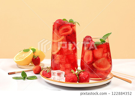 Strawberry Iced Tea or Mint Lemon Cocktail is a refreshing summer drink recipe. Glasses with berry fruit lemonade on a light concrete table, detox diet and weight loss concept, restaurant menu 122884352