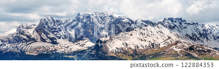 Majestic snow-capped mountain range under cloudy sky landscape panorama near Valley of Funes at Dolomites, Italy 122884353