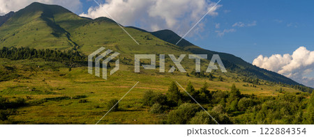 Panoramic View of Lush Green Hills Under Blue Sky Panoramic View of Lush Green Hills Under Blue Sky 122884354