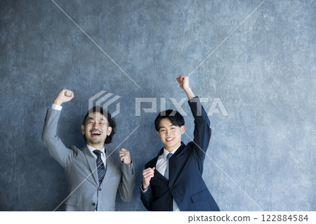 A smiling businessman doing a guts pose A smiling businessman doing a guts pose 122884584