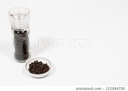 黑胡椒在研磨機中和盤子上 122884780