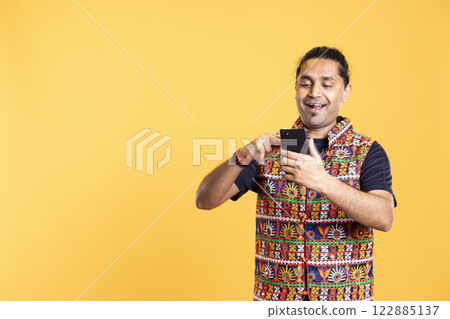 Man adding payment method on phone website, delighted to take advantage of promotions, studio background. Person thrilled to do internet shopping, typing credit card data on smartphone Man adding payment method on phone website, delighted to take advantage of promotions, studio background. Person thrilled to do internet shopping, typing credit card data on smartphone 122885137