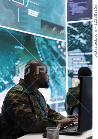 Government intelligence officers in a high tech command post oversee satellite data, manage real time surveillance footage via radar cctv and coordinate operations. Protecting national interests. Government intelligence officers in a high tech command post oversee satellite data, manage real time surveillance footage via radar cctv and coordinate operations. Protecting national interests. 122885158