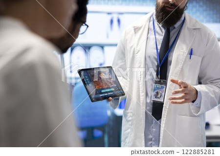 Expert medic analyze test results with his staff to find best treatment plan in a department meeting. Team of licensed doctors working together to provide radiology diagnostic, general expertise. 122885281