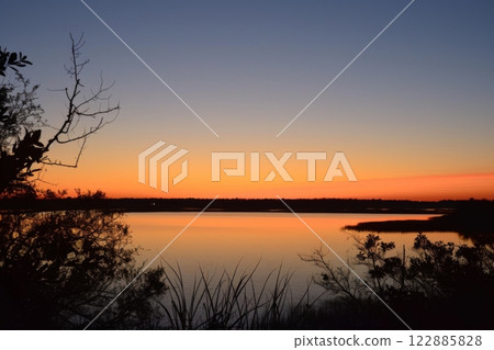 Vibrant Sunset Over Calm Water 122885828