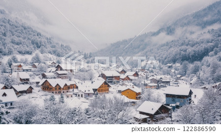 A snowy mountain town with houses and trees covered in snow 122886590