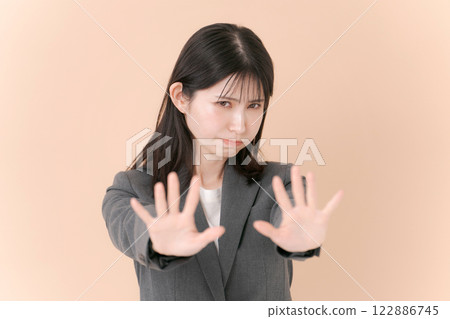 一名身穿西裝的女子擺出否認的姿勢 122886745