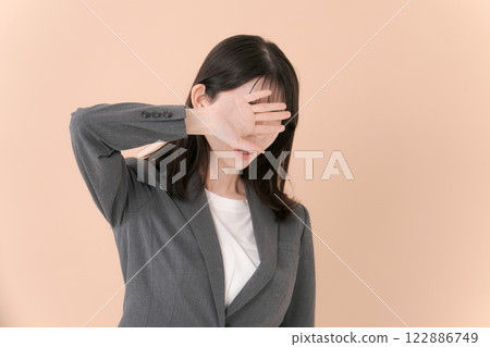 一名身穿西裝遮住臉的女性 一名身穿西裝遮住臉的女性 122886749