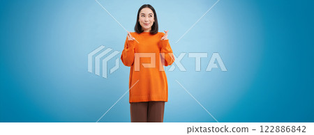 Portrait of asian woman cross fingers, hopes and prays for something, makes a wish, stands over blue background 122886842