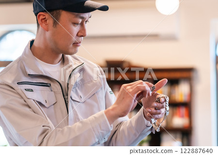 A male professional appraising a watch in the living room A male professional appraising a watch in the living room 122887640