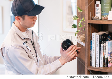 一位男性專業人士在客廳評估相機鏡頭 一位男性專業人士在客廳評估相機鏡頭 122887643