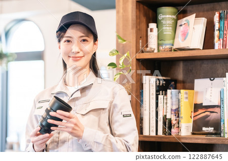 A female professional appraising a camera lens in the living room 122887645