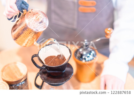 一位年輕的女銷售助理用滴濾壺煮咖啡，沒有臉 122887658