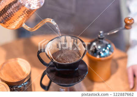 一位年輕的女銷售助理用滴濾壺煮咖啡，沒有臉 122887662