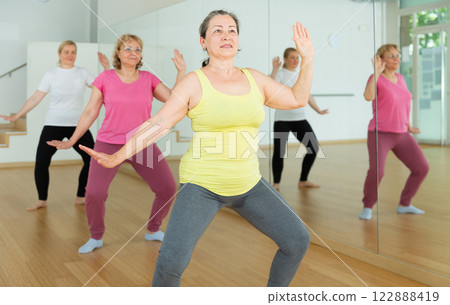 Mature women dancing aerobics at lesson in dance class 122888419