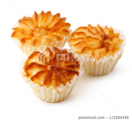 Delicious coconut macaroons with a golden brown crust arranged on a white surface for an enticing display Delicious coconut macaroons with a golden brown crust arranged on a white surface for an enticing display 122888486