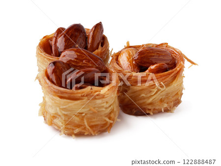Sweet dessert featuring thin crispy pastry filled with nuts, served on a white background Sweet dessert featuring thin crispy pastry filled with nuts, served on a white background 122888487