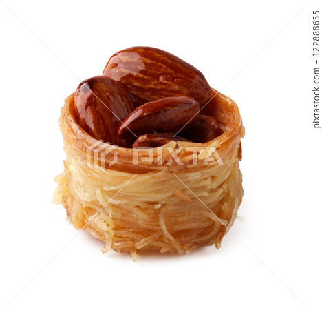 Traditional Middle Eastern dessert made with crispy pastry and roasted nuts served on a white background Traditional Middle Eastern dessert made with crispy pastry and roasted nuts served on a white background 122888655