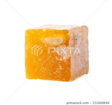 Yellow fruit-flavored confectionary cube with nut pieces on a white background 122888698