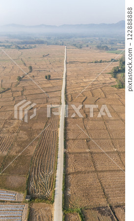 Aerial view countryside road cutting through agriculture field in Chae Hom District of Lampang Province, Thailand. 122888888