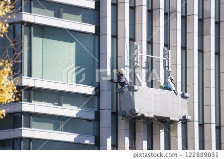 一名男子正在清潔建築物的窗戶 一名男子正在清潔建築物的窗戶 122889031
