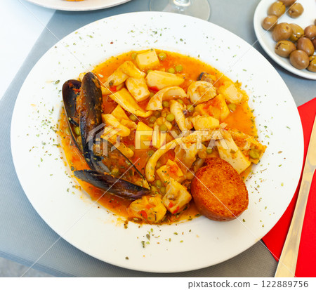 Tasty dish of spanish cuisine fried sepia with mussels in sauce Tasty dish of spanish cuisine fried sepia with mussels in sauce 122889756