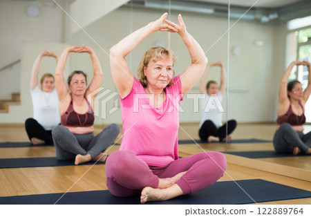 People studying new position at yoga school 122889764