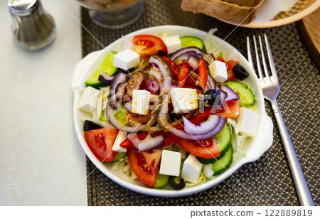 Plate of tasty Greek salad with fresh cucumbers, bell pepper and feta cheese Plate of tasty Greek salad with fresh cucumbers, bell pepper and feta cheese 122889819