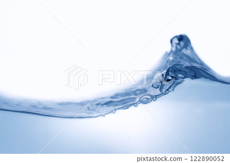 Closeup view of dynamic flowing blue water waves on white background. Liquid splash. Texture and abstract background Closeup view of dynamic flowing blue water waves on white background. Liquid splash. Texture and abstract background 122890052
