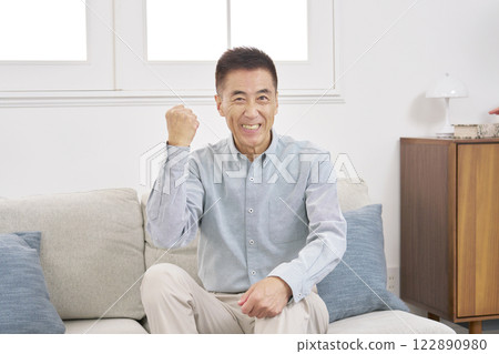 Senior man, fist pump, living room 122890980