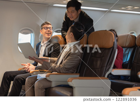 Happiness business people working together on laptop during flight Happiness business people working together on laptop during flight 122891036